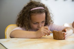 Une petite fille réalisant une poterie.